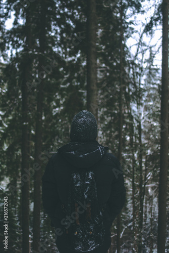 Man traveler admires the winter forest landscape © Yurii Zymovin