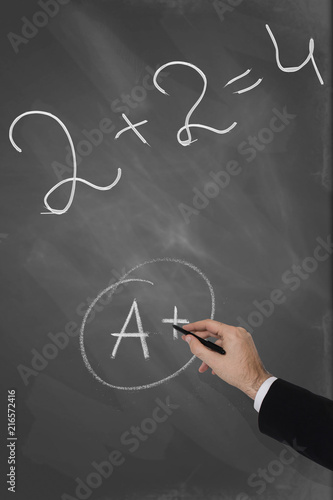 Teacher checking math problem on a blackboard