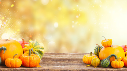 pile of orange pumpkins on wooden table over fall background banner