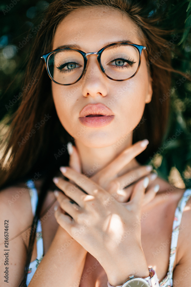 Closeup emotional artistic portrait of amazing fabulous beautiful young  cheerful model girl with big natural lips and blue passionate eyes looking  at camera outdoor at nature. Cute lovely teen face. foto de