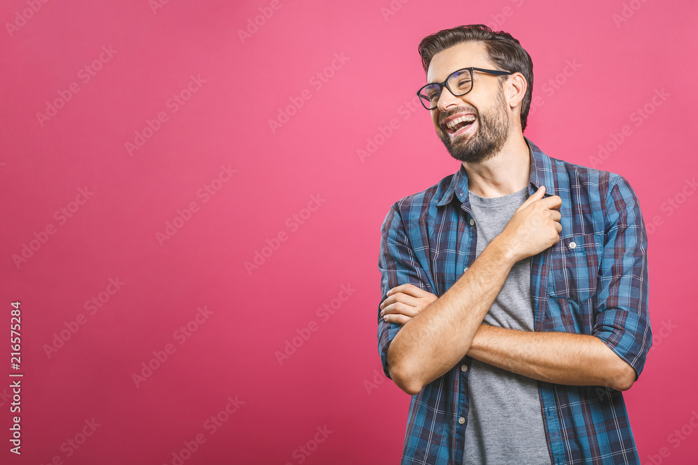 Portrait of a handsome casual man who laughs, standing and laughing over pink background - obrazy, fototapety, plakaty 