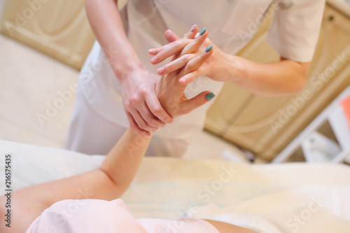 the massage therapist hands massage to a young beautiful pregnant girl