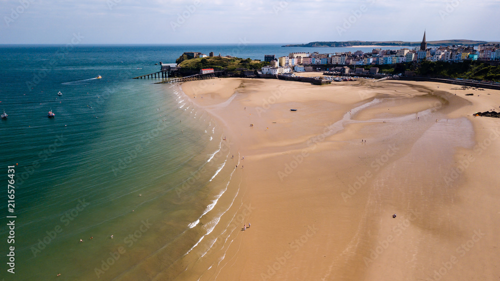 Boats stranded at low tide on a huge, sandy beach at a colorful, picturesque coastal town Boats stranded at low tide on a huge, sandy beach at a colorful, picturesque coastal town
