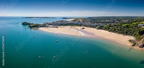 Aerial drone view of a beautiful coast town with sandy beaches and colorful buildings  Tenby  Wales  UK 