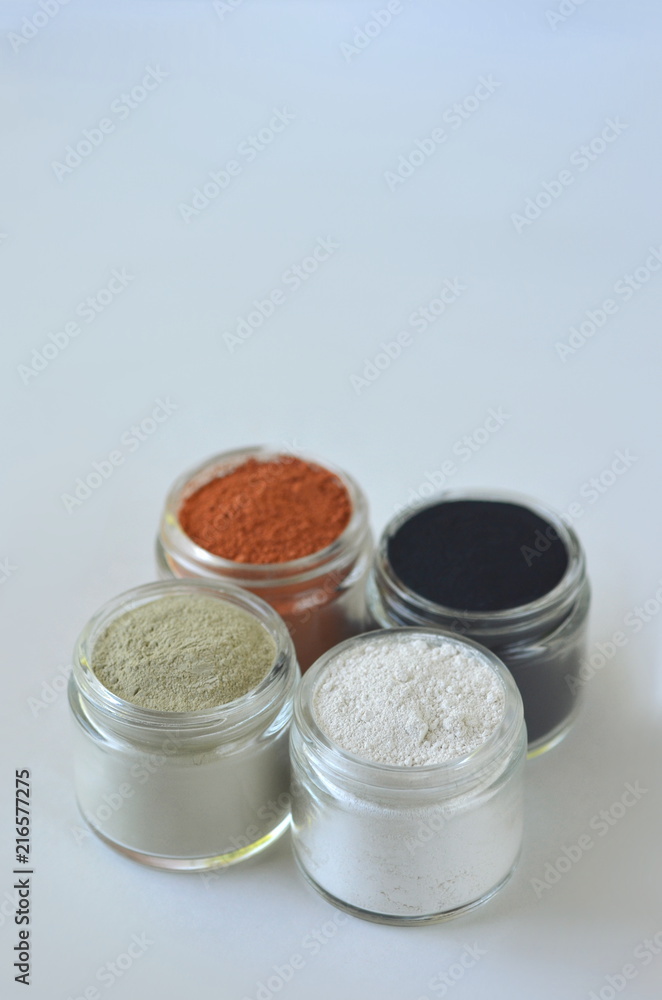 Top view of kaolin powder, activated charcoal, red, green and green cosmetic clays in jars. Deep cleansing bentonite (montmorillonite) clay for beauty spa face mask, body detox and hair treatments. Top view of kaolin powder, activated charcoal, red, green and green cosmetic clays in jars. Deep cleansing bentonite (montmorillonite) clay for beauty spa face mask, body detox and hair treatments.