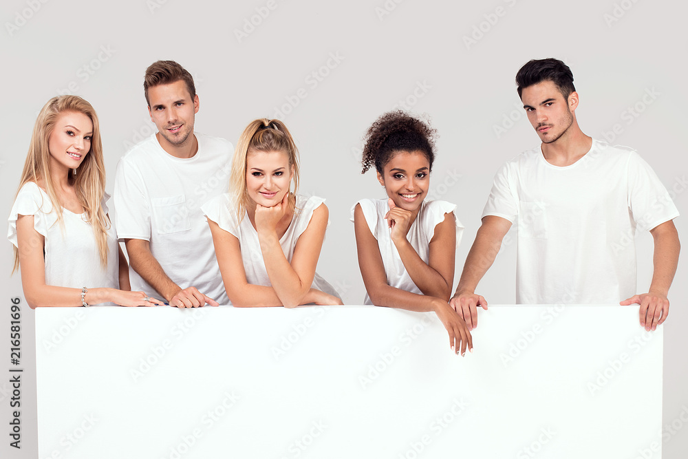 Group of smiling people with empty white board. Group of smiling people with empty white board.