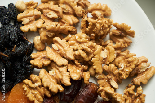 Mix of dry nuts and fruits. Composition with dried fruits and assorted nuts on white plates, top view