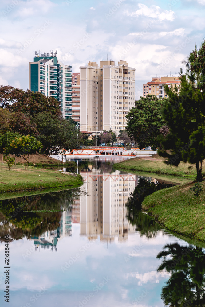 Buildings reflected on the water of a river, in the Ecological Park, in Indaiatuba, Brazil.