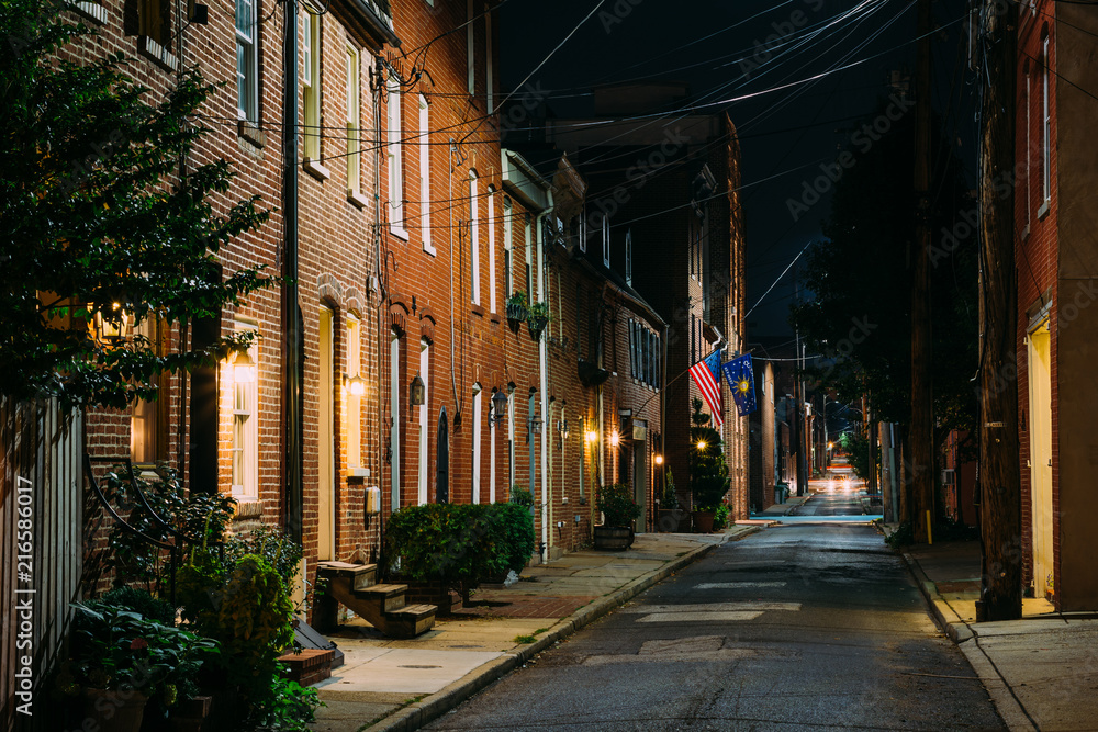 American flag and row houses on Bethel Street at night, in Fells Point, Baltimore, Maryland