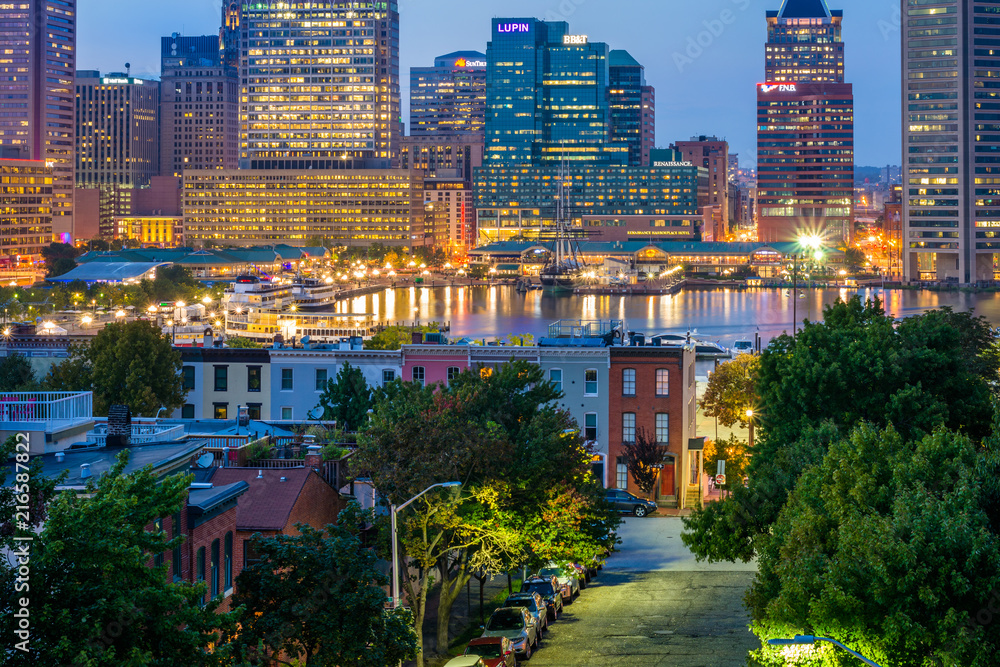 View of Federal Hill row houses and the Inner Harbor at night, in Baltimore, Maryland