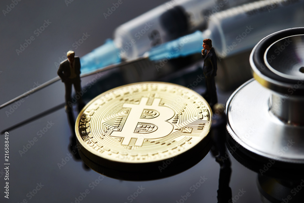 Fototapeta premium Bitcoin with miniature men and medical equipment