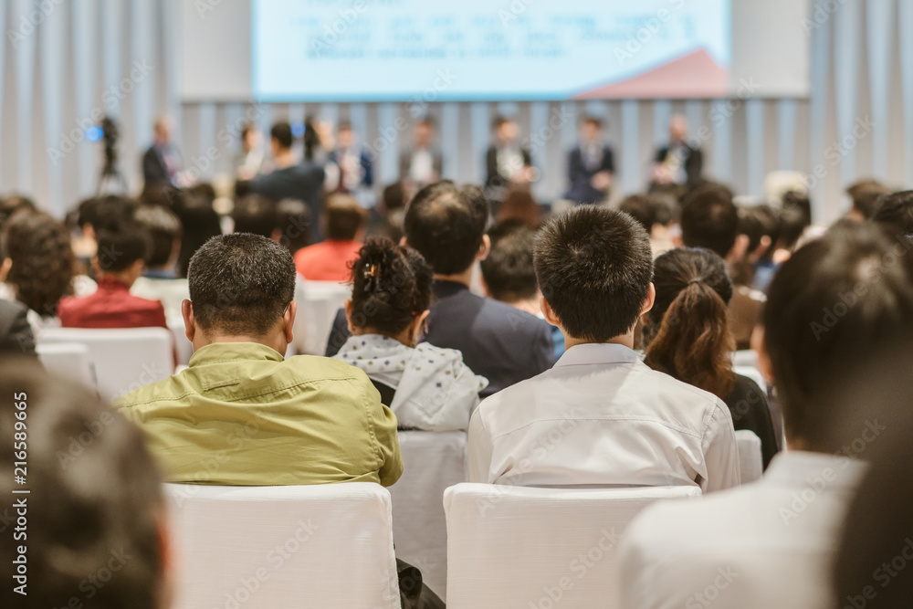 Obraz premium Speakers on the stage with Rear view of Audience in the conference hall or seminar meeting, business and education about investment concept