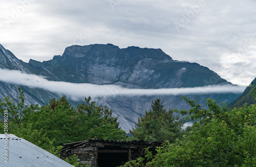 A wispy cloud cuts across a granite formation in the Himalayas on the Annapurna Circuit