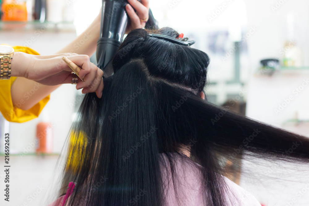 Naklejka premium women in beauty hair salon . hairdresser blow dry hair , barber making hairstyle and mirror .