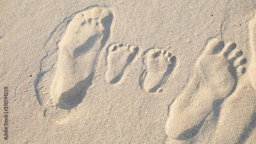 The parents' footprint besides the little cute footprint of their baby.