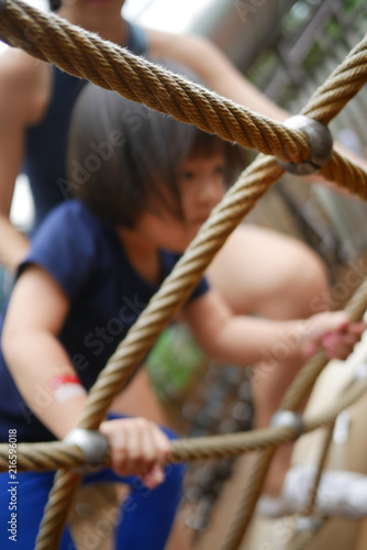 Asian Chinese Child climbing rope obstacle course