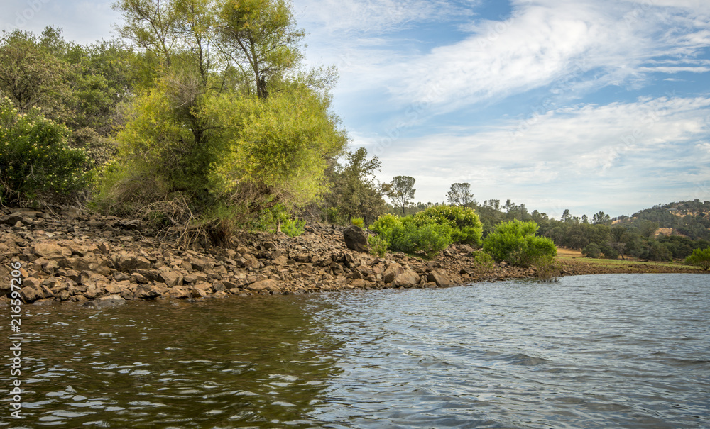 Rocky lake edge, trees and bushes on bank of beautiful, Northern Californian lake Rocky lake edge, trees and bushes on bank of beautiful, Northern Californian lake