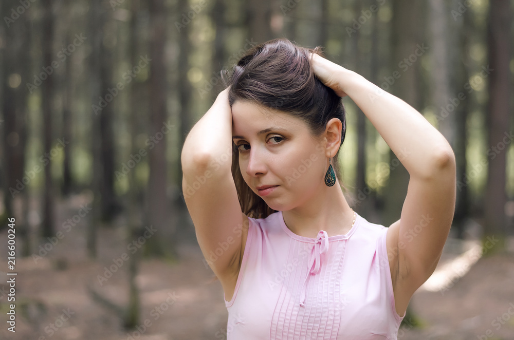 Young pensive woman posing in the forest.