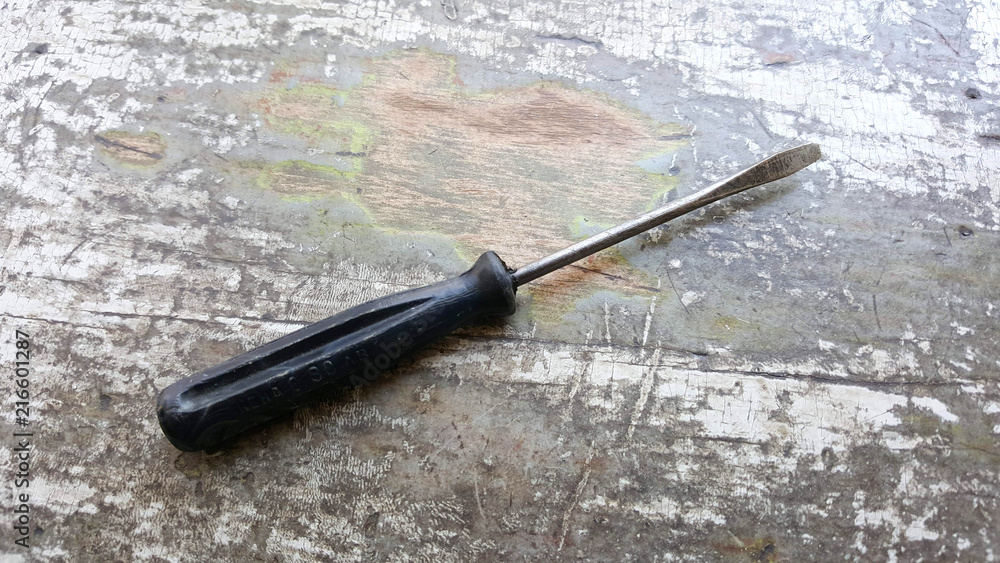 screwdriver on an old painted wod background screwdriver on an old painted wod background