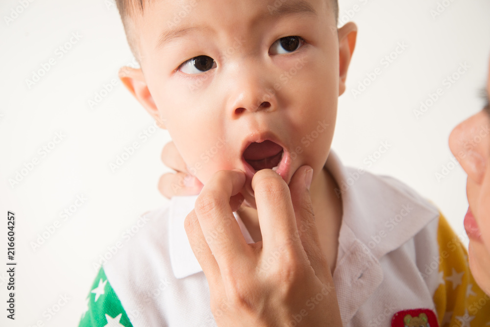 Asian boy take a toothbrush cleaning teeth by his mother Asian boy take a toothbrush cleaning teeth by his mother