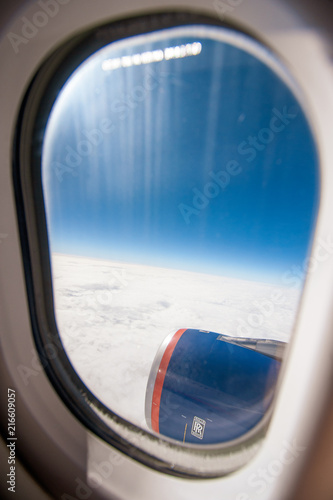 Plane window view with blue sky