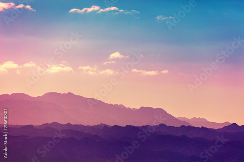 Sunset over mountains. Silhouette of a mountain range against sky at sunset