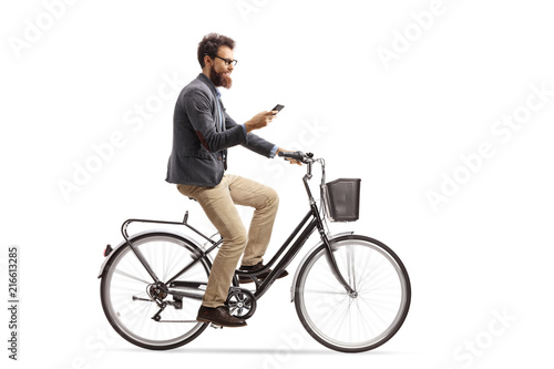 Young man riding a bicycle and looking at his phone
