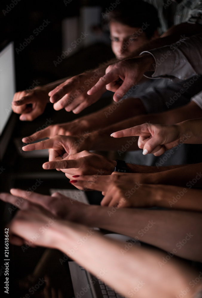business team pointing their fingers at the blank computer screen