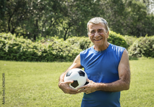 Mature man holding a football © Rawpixel.com