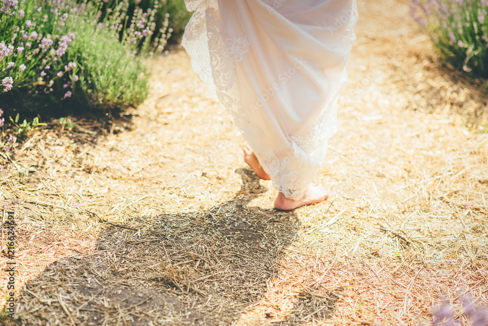 Beautiful young woman bride is walking on the field Beautiful young woman bride is walking on the field