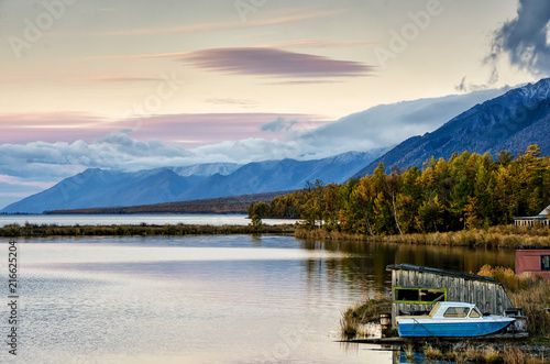Autumn forest lake landscape with mountain and boat © kuzenkova