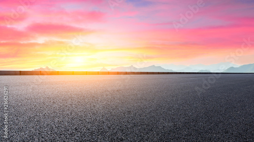 Empty asphalt road and great wall with mountains at sunset
