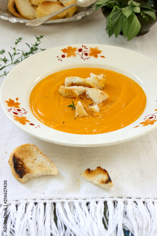 Vegan carrot or pumpkin cream soup served with croutons and thyme. Rustic style. Vegan carrot or pumpkin cream soup served with croutons and thyme. Rustic style.