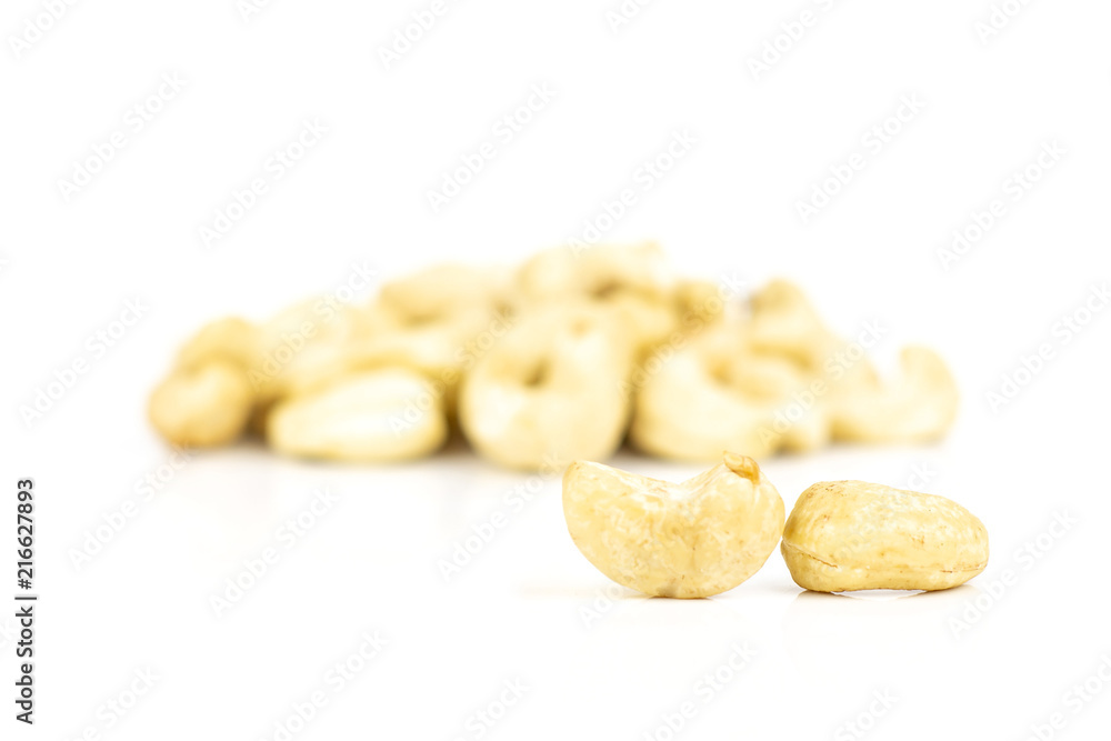 Lot of whole raw cashew nut two in focus isolated on white background