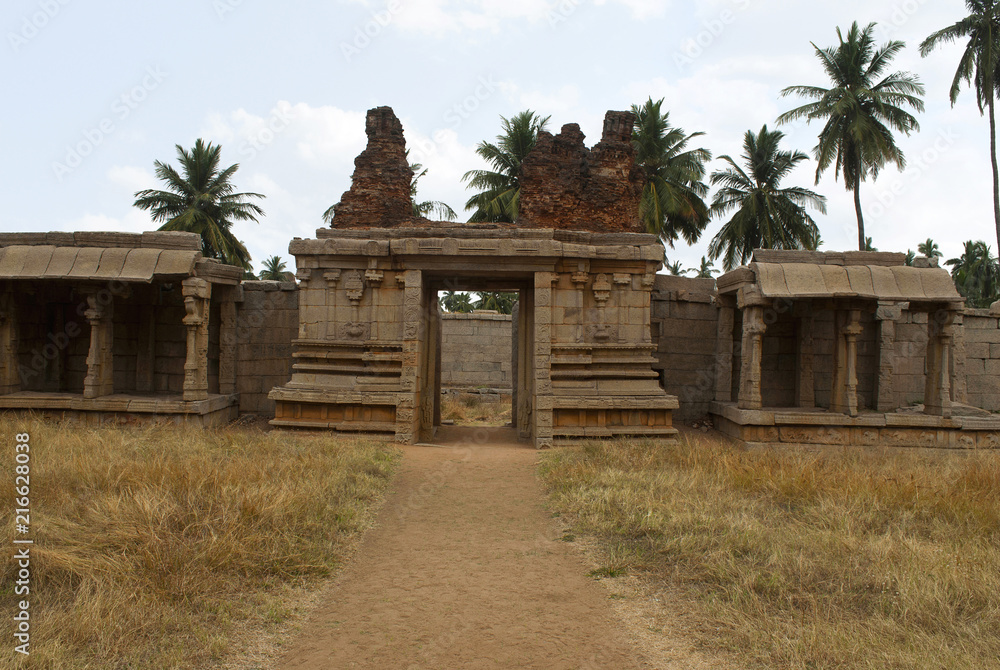 Carved pillars of the inner courtyard, cloisters or pillared verandah and the east gopura. Achyuta Raya temple, Hampi, Karnataka. Sacred Center. View from the west side.