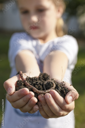 Child Holding Heap of Dirt with Earthworm on Top