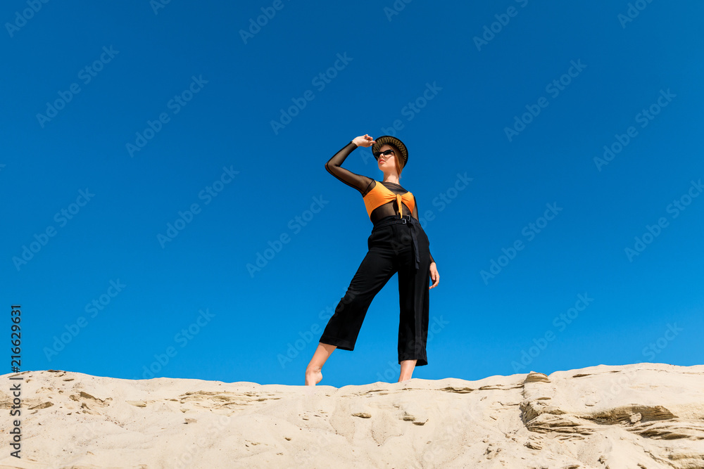 beautiful young woman posing in fashionable clothes with blue sky on background beautiful young woman posing in fashionable clothes with blue sky on background
