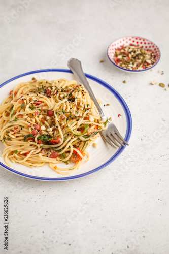 Healthy vegan pasta with zucchini, tomatoes and nuts.