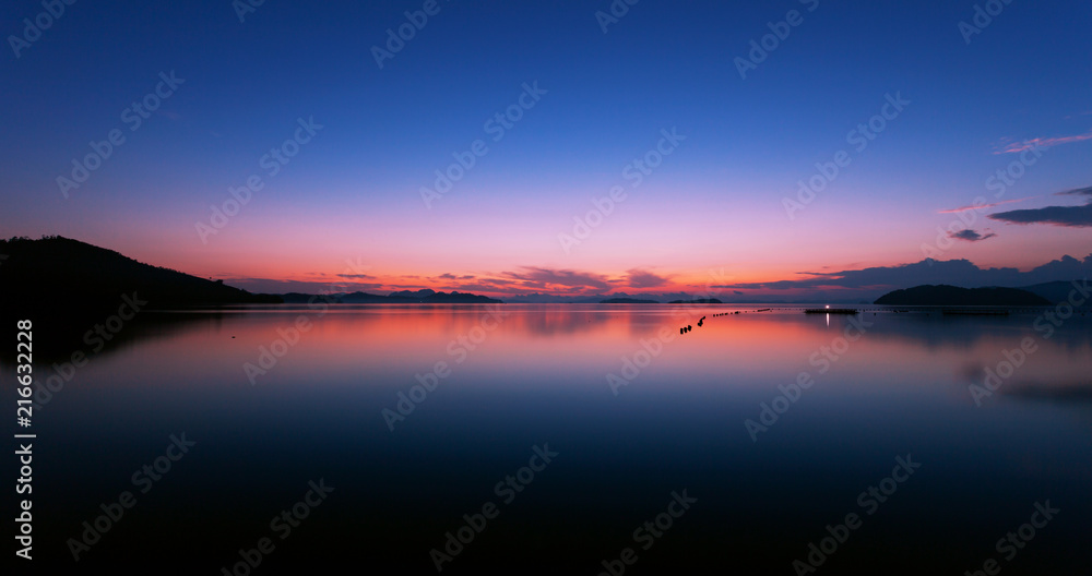 Fototapeta premium Long exposure image of Dramatic color sky seascape with reflection in sunset or sunrise scenery nature for background.