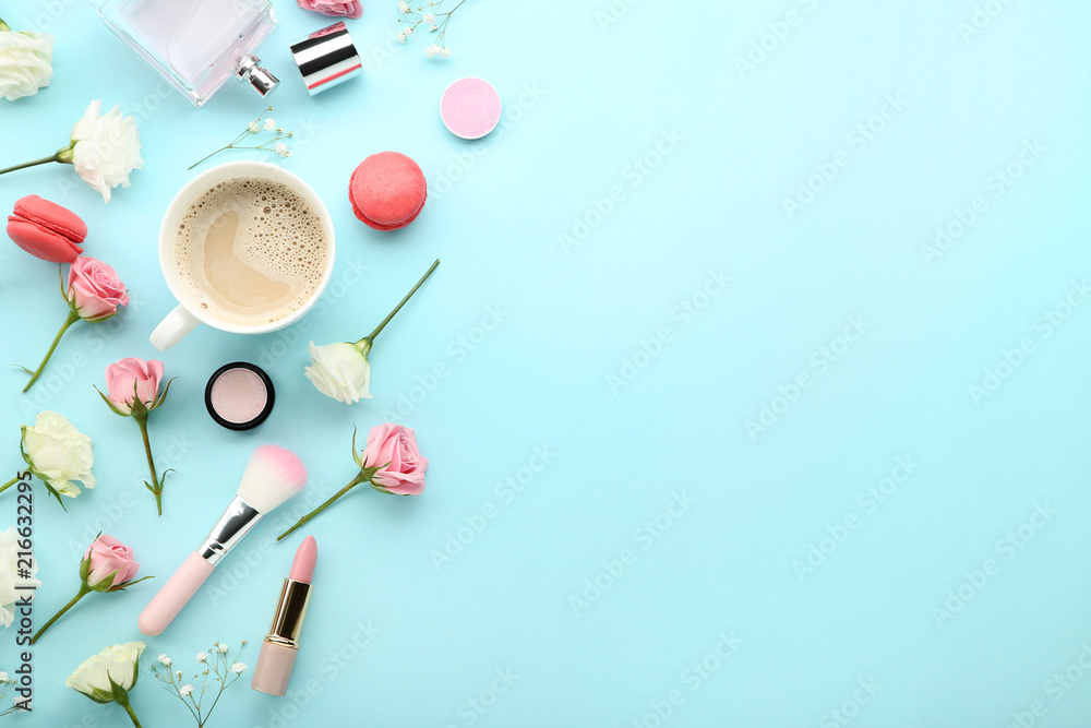 Flowers with cup of coffee and makeup cosmetics on blue background Flowers with cup of coffee and makeup cosmetics on blue background