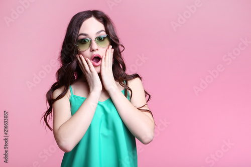 Beautiful young woman with sunglasses on pink background © 5second