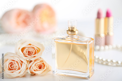 Perfume bottle with roses on white background