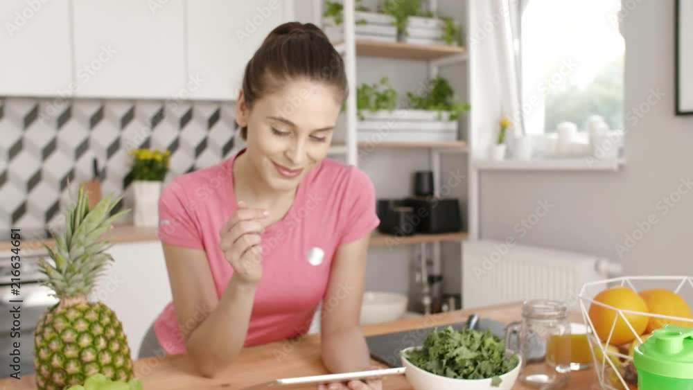 Woman using a tablet during the cooking at kitchen Woman using a tablet during the cooking at kitchen