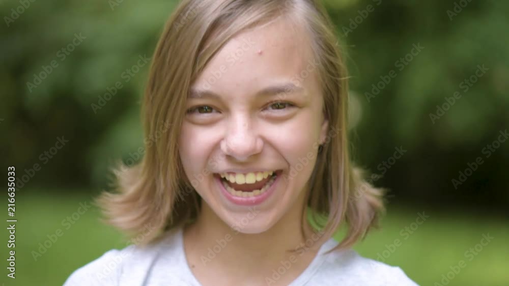 Close up emotional portrait of caucasian smiling teen girl. Funny cute teenager in summer park at day. Child looking at camera. Close up emotional portrait of caucasian smiling teen girl. Funny cute teenager in summer park at day. Child looking at camera.