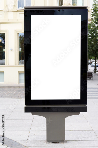 A modern advertising stand is installed on the street of the old city