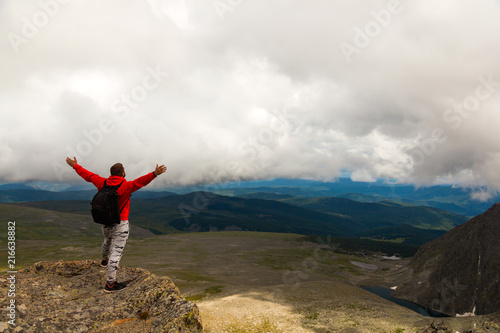 Man hiker enjoy the view at sunset mountain peak cliff.Photographer traveler on high mountaint Stylish man hiking. Travel Lifestyle and survival concept rear view