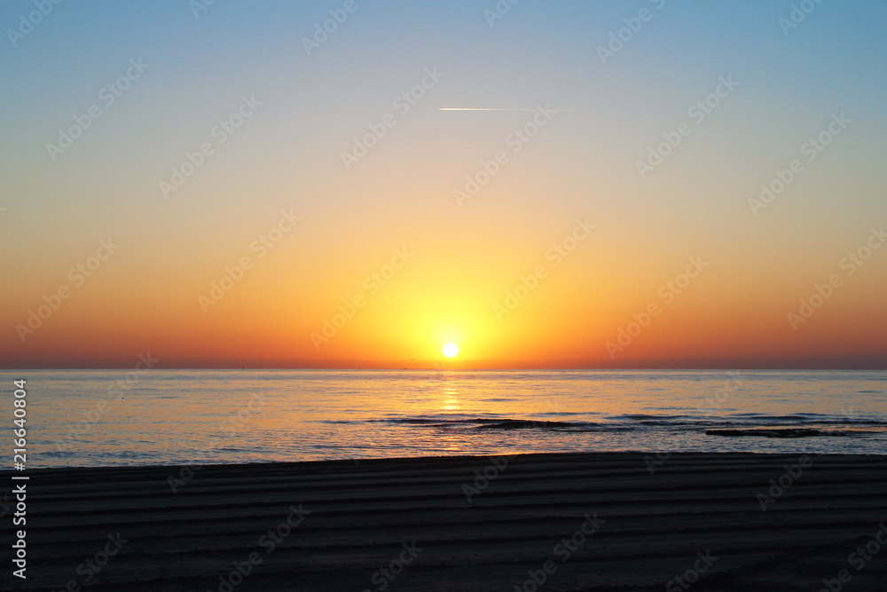 Sunrise or sunset on the beach.