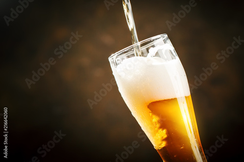 A glass of beer on a dark background.