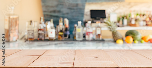  Bar with the shelf of alcoholic drinks. Empty wooden table top for you product presentation.