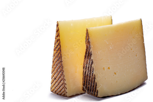 Two pieces of Manchego, queso manchego, cheese made in La Mancha region of Spain from the milk of sheep of the manchega breed, isolated on white photo